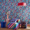 busy blue wallpaper with striped chair and mixed side tables