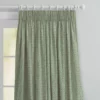 top half of green floral curtains with pink flowers in pencil pleat heading on a white wooden pole