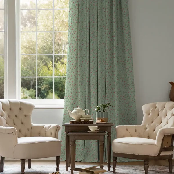 Bell Meadow Fabric - Oasis by green floral curtains at a window with 2 cream armchairs in front. A wooden table with a tea set in between.