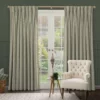 sage green floral curtains at a set of french doors with a white armchair and wooden table