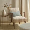 green striped armchair with cushion and pouf