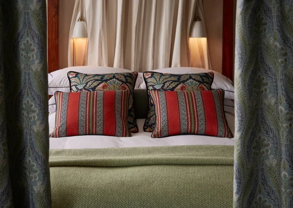 Severino Fabric - Lava by red striped cushion with bed and curtain