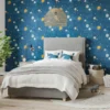 blue wallpaper with planets and moons with bed