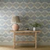 blue botanical wallpaper and wall with side table and vases