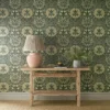 green botanical wallpaper and wall with side table and vases