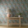 blue botanical wallpaper and wall with side table and vases