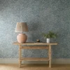 blue botanical wallpaper and wall with side table and vases