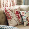 red botanical cushion with curtain and sofa