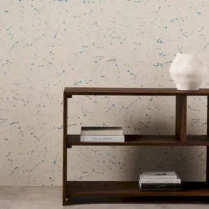 blue spotted wallpaper and wall with bookshelf and vases