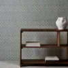 blue spotted wallpaper and wall with bookshelf and vases