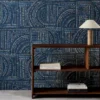 blue geometric wallpaper and wall with bookshelf and vases