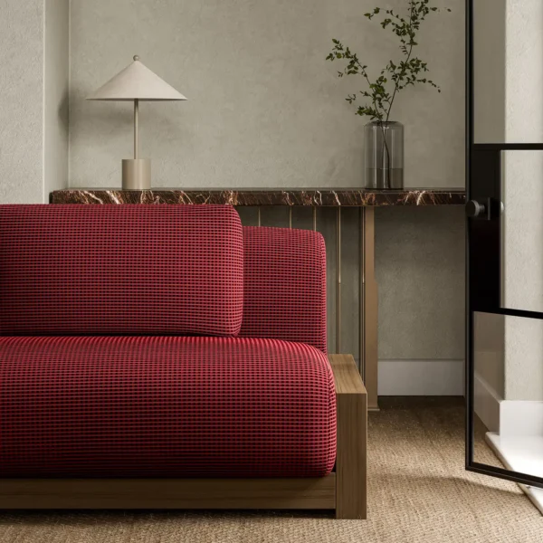 Ore Fabric - Rhodonite by red plain sofa with side table and vases