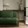 green plain sofa with side table and vases