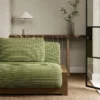 green plain sofa with side table and vases