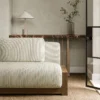white striped sofa with side table and vases