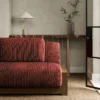 purple striped sofa with side table and vases