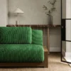 green striped sofa with side table and vases