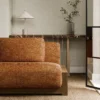 orange plain sofa with side table and vases