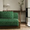 green plain sofa with side table and vases
