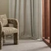 blue spotted curtain with armchair and window