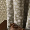 green spotted curtain with wall and cushion