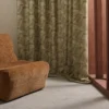 green geometric curtain with armchair and window