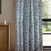 blue botanical curtain with cabinets and window