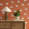 orange animal wallpaper and wall with cabinets and vases