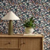 blue botanical wallpaper and wall with cabinets and vases