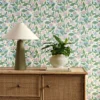 green botanical wallpaper and wall with cabinets and vases