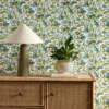 blue botanical wallpaper and wall with cabinets and vases