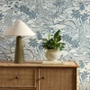 blue botanical wallpaper and wall with cabinets and vases