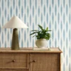 blue striped wallpaper and wall with cabinets and vases