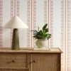 pink striped wallpaper and wall with cabinets and vases