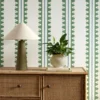 green striped wallpaper and wall with cabinets and vases