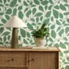 green botanical wallpaper and wall with cabinets and vases
