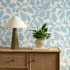 blue botanical wallpaper and wall with cabinets and vases