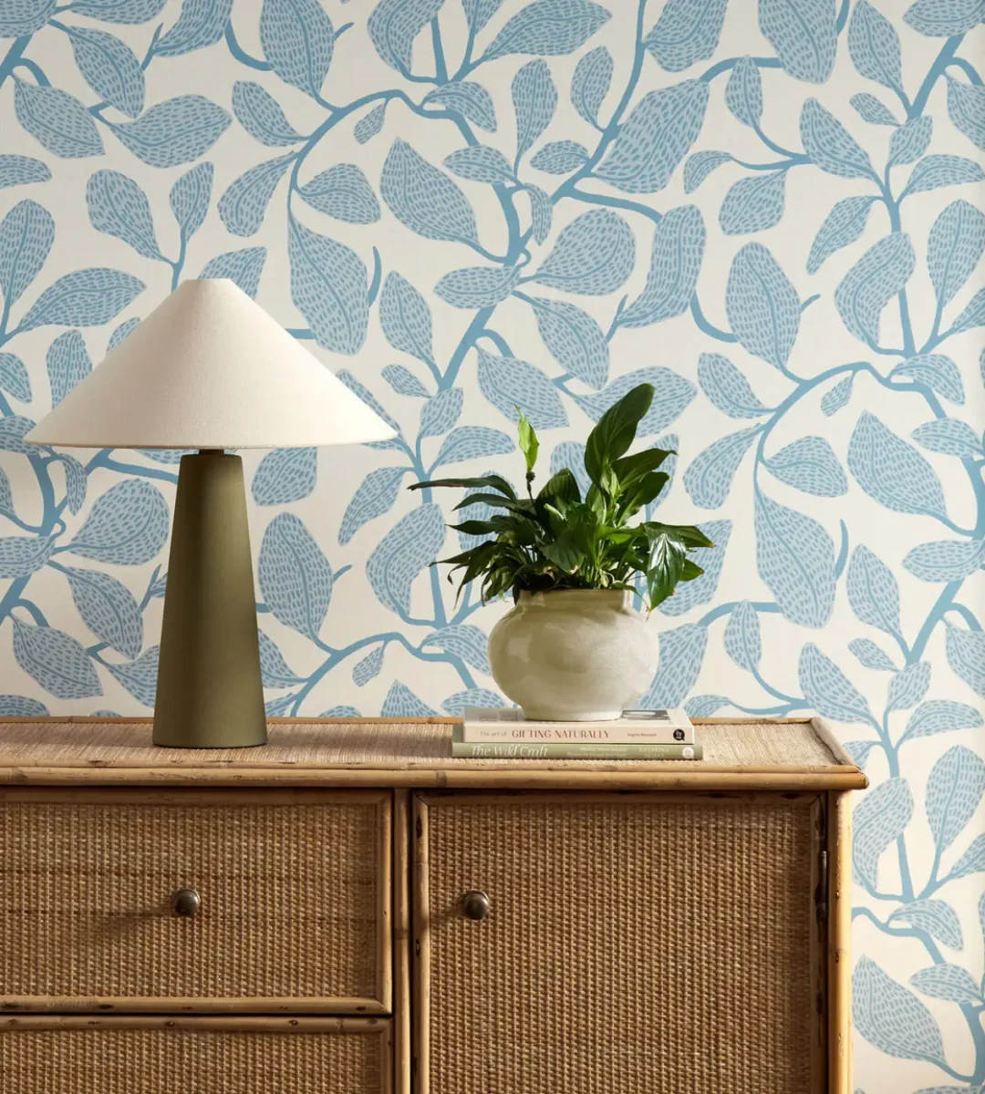 blue botanical wallpaper and wall with cabinets and vases