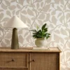 neutral botanical wallpaper and wall with cabinets and vases
