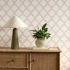 pink geometric wallpaper and wall with cabinets and vases