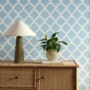 blue geometric wallpaper and wall with cabinets and vases