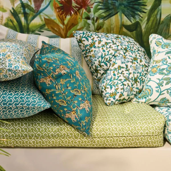 Hathi Fabric - Teal by green botanical cushion with sofa and wall