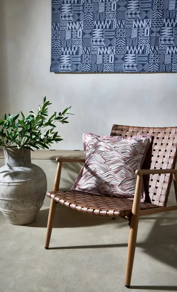 Imara Fabric - Rattan by red misc wall with cushion and chair