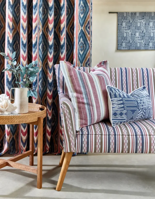 Imara Fabric - Rattan by red striped sofa with cushion and curtain