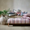 red striped bed with cushion and vases