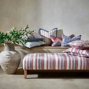 red striped bed with cushion and vases