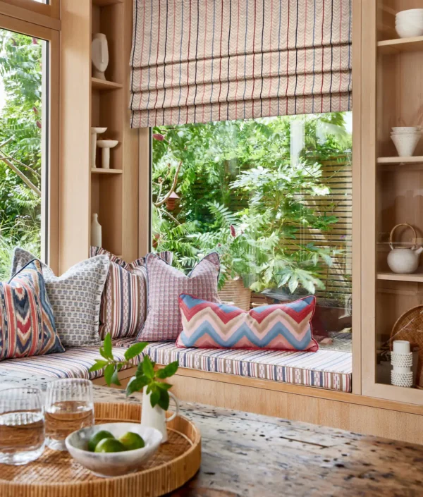 Kitwana Fabric - Ocean by green striped blind with cushion and window