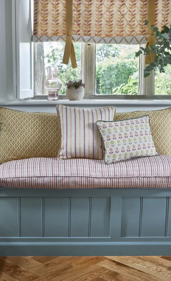 June Fabric - Raspberry by green botanical curtain with cushion and armchair