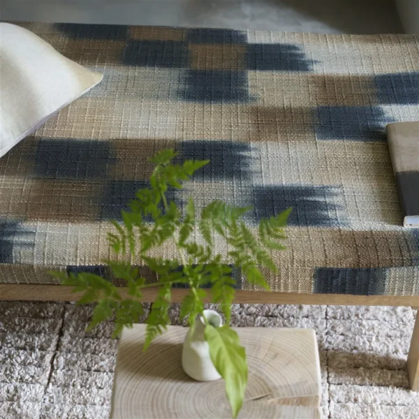 brown checked bed with cushion and vases