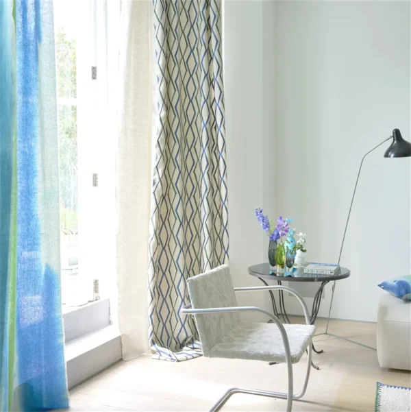 Trevenna Fabric - Cobalt by blue geometric curtain with armchair and vases